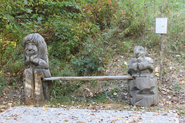 Stone and wood bench beside a wooded path